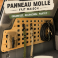 Panneau Molle DIY accroché dans une salle de séjour, décoratif et pratique.